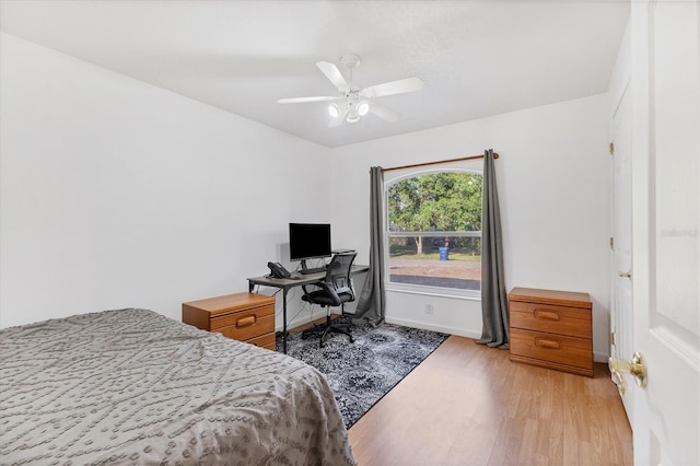bedroom with baseboards, ceiling fan, and light wood-style floors