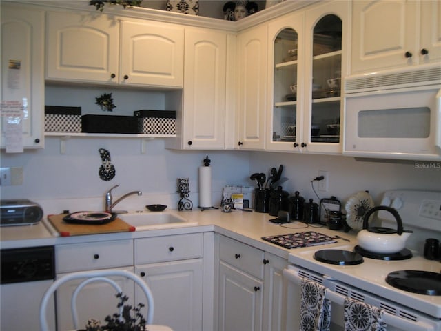 kitchen with a sink, white appliances, white cabinetry, and light countertops