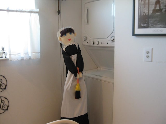 clothes washing area with stacked washer and dryer and laundry area