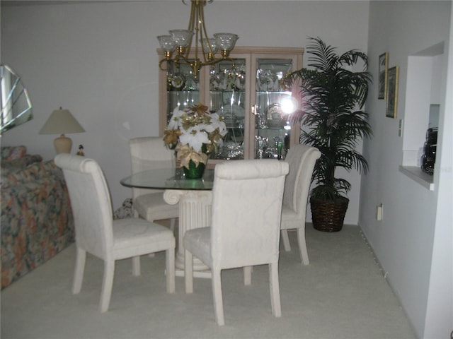 dining room with carpet floors and a chandelier