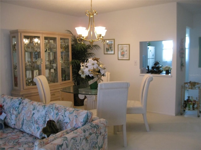 dining space featuring light colored carpet and an inviting chandelier