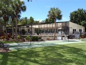 view of sport court featuring a lawn