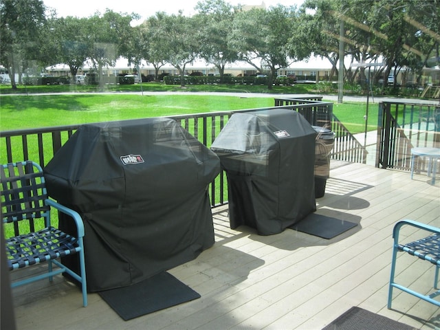 wooden terrace featuring a grill and a lawn