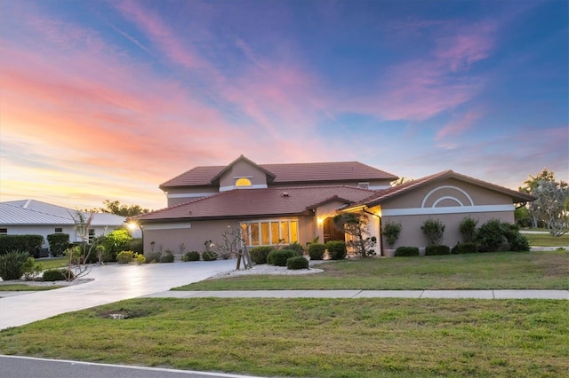 4405 Harbor Blvd, Port Charlotte, FL 33952 - view of front of house with stucco siding, a lawn, a tile roof, and concrete driveway