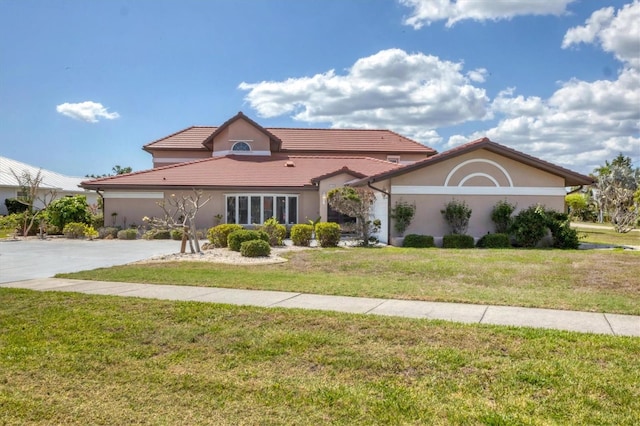 4405 Harbor Blvd, Port Charlotte, FL 33952 - view of front of property with a front yard, stucco siding, and a tile roof