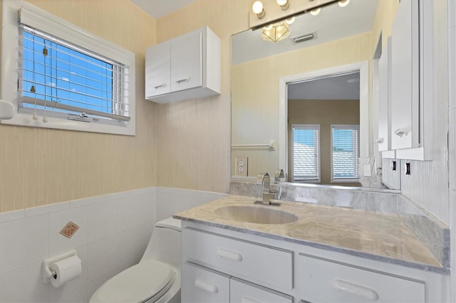 4405 Harbor Blvd, Port Charlotte, FL 33952 - half bath featuring toilet, vanity, a wainscoted wall, and tile walls