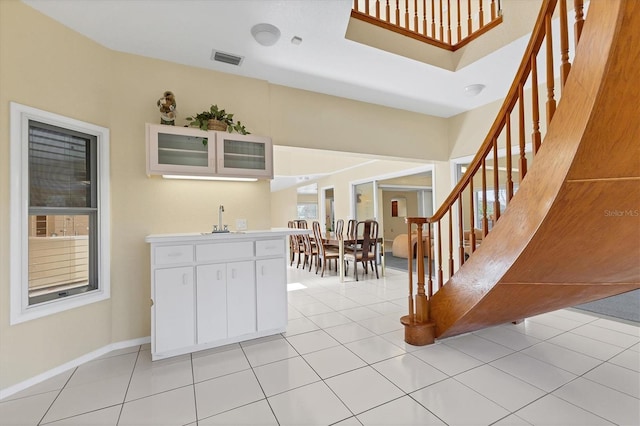 4405 Harbor Blvd, Port Charlotte, FL 33952 - kitchen with white cabinetry, a sink, glass insert cabinets, light countertops, and baseboards