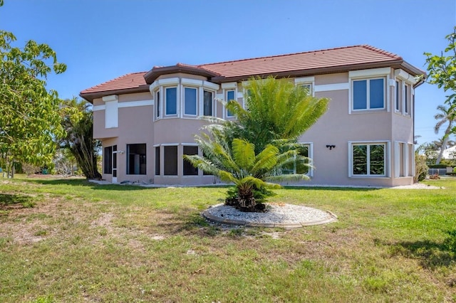 4405 Harbor Blvd, Port Charlotte, FL 33952 - rear view of property with stucco siding, a tile roof, and a yard