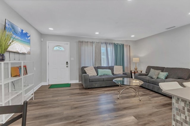 living room with baseboards, wood finished floors, visible vents, and recessed lighting