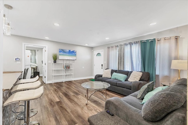 living room with baseboards, wood finished floors, and recessed lighting