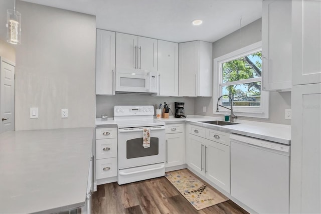 kitchen with white cabinets, light countertops, white appliances, and a sink