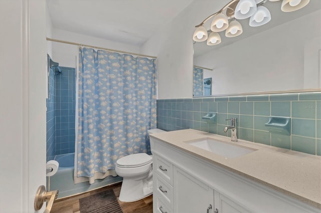 full bathroom featuring shower / bath combo, wood finished floors, vanity, tile walls, and toilet