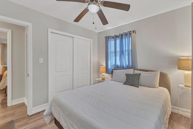 bedroom with ceiling fan, baseboards, wood finished floors, and a closet