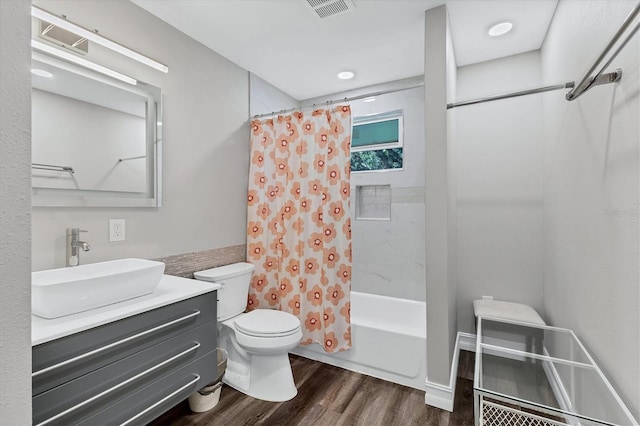 full bath with wood finished floors, vanity, visible vents, toilet, and shower / bath combo with shower curtain