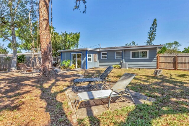 rear view of property featuring central AC unit, fence, and a patio