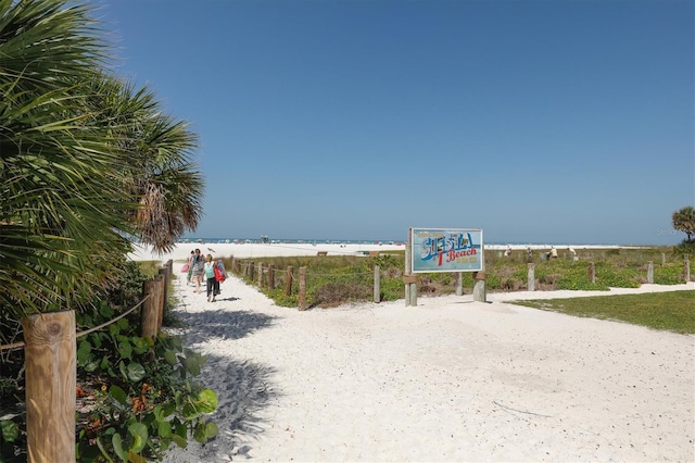view of home's community with a water view and a beach view