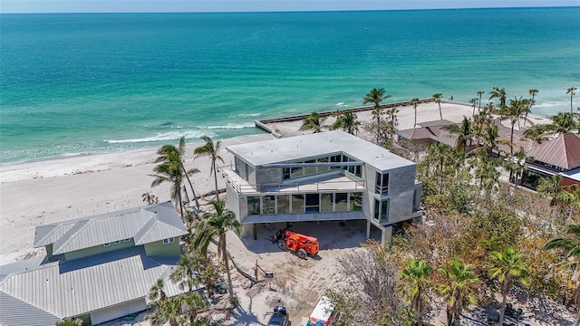 birds eye view of property featuring a beach view and a water view