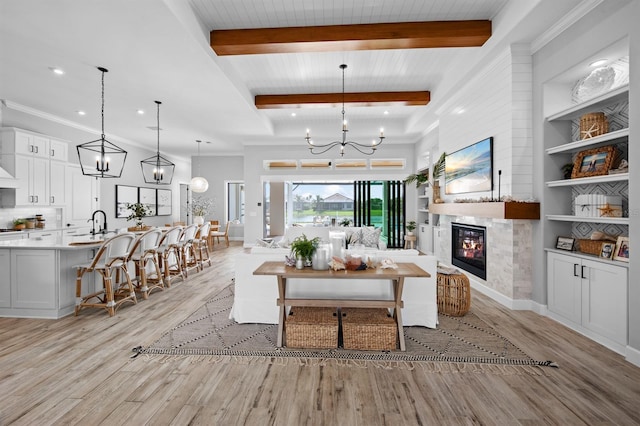 11611 Roseto Ct, Fort Myers, FL 33913 - living room featuring light wood-style floors, a chandelier, beamed ceiling, a glass covered fireplace, and recessed lighting