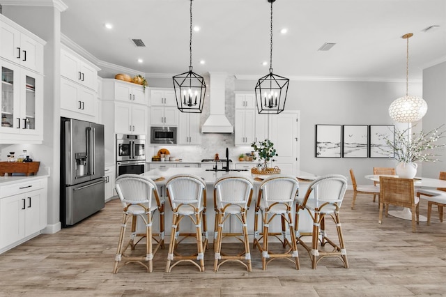 11611 Roseto Ct, Fort Myers, FL 33913 - kitchen with stainless steel appliances, custom exhaust hood, ornamental molding, a breakfast bar, and a chandelier