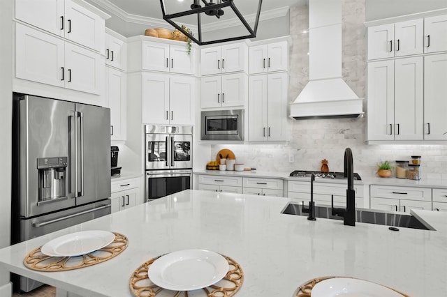 11611 Roseto Ct, Fort Myers, FL 33913 - kitchen with custom range hood, stainless steel appliances, crown molding, backsplash, and white cabinets