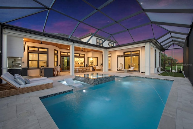 11611 Roseto Ct, Fort Myers, FL 33913 - back of property at dusk with area for grilling, a ceiling fan, a patio, a pool with connected hot tub, and an outdoor living space