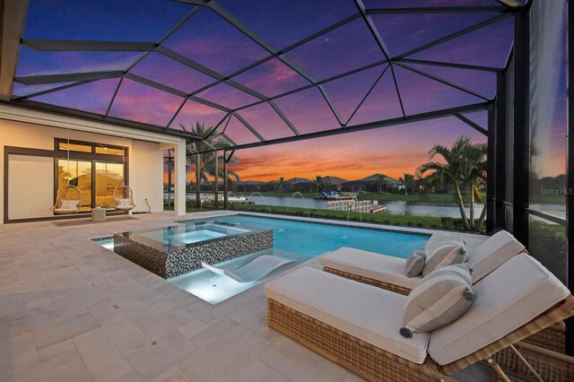 11611 Roseto Ct, Fort Myers, FL 33913 - view of swimming pool with a patio area, a pool with connected hot tub, a water view, glass enclosure, and an outdoor living space