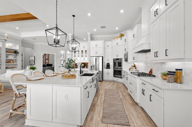 11611 Roseto Ct, Fort Myers, FL 33913 - kitchen featuring a sink, a chandelier, a breakfast bar, appliances with stainless steel finishes, and backsplash