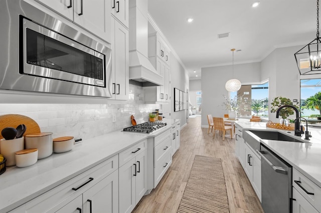 11611 Roseto Ct, Fort Myers, FL 33913 - kitchen with stainless steel appliances, a sink, premium range hood, a chandelier, and recessed lighting