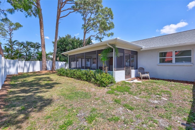 3978 Lemonwood Dr, Sarasota, FL 34232 - back of property featuring a yard, a fenced backyard, a sunroom, and stucco siding
