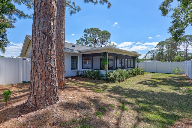 3978 Lemonwood Dr, Sarasota, FL 34232 - exterior space with a fenced backyard, a sunroom, a lawn, and stucco siding