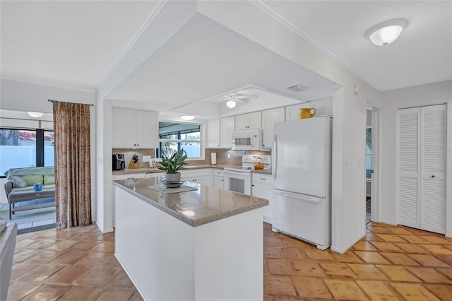 3978 Lemonwood Dr, Sarasota, FL 34232 - kitchen with white appliances, a center island, white cabinetry, backsplash, and a ceiling fan