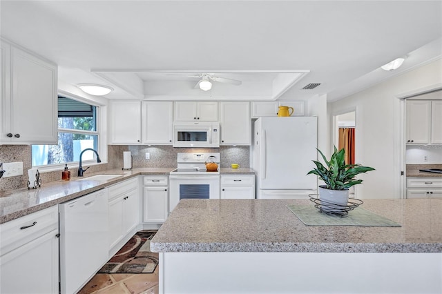 3978 Lemonwood Dr, Sarasota, FL 34232 - kitchen with white appliances, a tray ceiling, visible vents, white cabinets, and a sink
