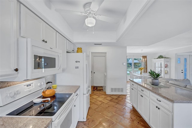 3978 Lemonwood Dr, Sarasota, FL 34232 - kitchen with visible vents, white cabinets, a ceiling fan, white appliances, and a tray ceiling