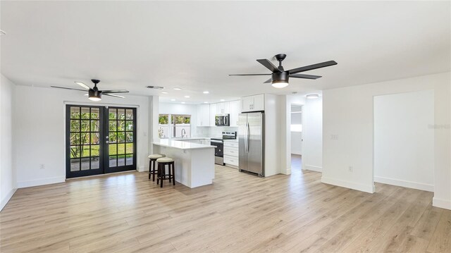 6628 Keystone Dr, Sarasota, FL 34231 - kitchen featuring appliances with stainless steel finishes, a ceiling fan, open floor plan, a kitchen breakfast bar, and light countertops
