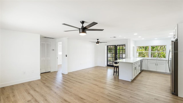 6628 Keystone Dr, Sarasota, FL 34231 - kitchen with open floor plan, a breakfast bar, ceiling fan, light wood-style flooring, and recessed lighting