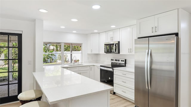 6628 Keystone Dr, Sarasota, FL 34231 - kitchen with appliances with stainless steel finishes, a sink, healthy amount of natural light, a kitchen breakfast bar, and recessed lighting