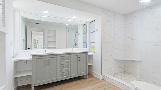 6628 Keystone Dr, Sarasota, FL 34231 - bathroom featuring a tile shower, wood finished floors, recessed lighting, double vanity, and toilet