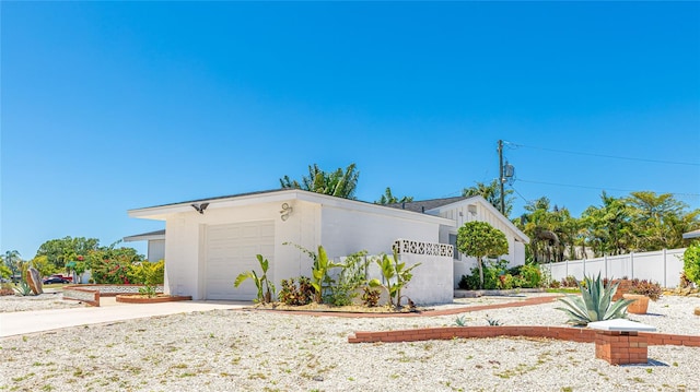 6628 Keystone Dr, Sarasota, FL 34231 - view of side of property with fence, driveway, and a garage