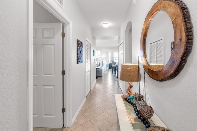 7803 Grand Estuary Trl Unit 102, Bradenton, FL 34212 - hallway featuring a textured wall, light tile patterned floors, visible vents, and baseboards