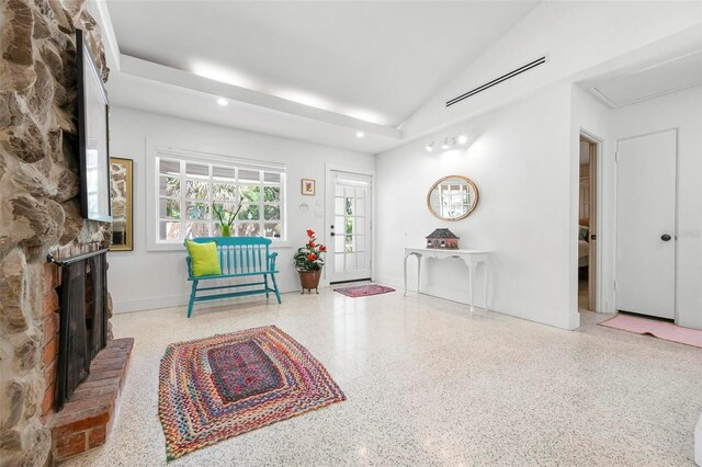 sitting room with speckled floor, lofted ceiling, a brick fireplace, visible vents, and recessed lighting