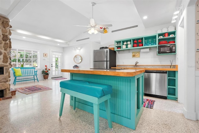 kitchen with recessed lighting, butcher block counters, light speckled floor, and appliances with stainless steel finishes