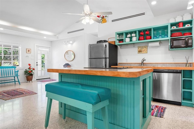 kitchen featuring light speckled floor, appliances with stainless steel finishes, open shelves, and wooden counters