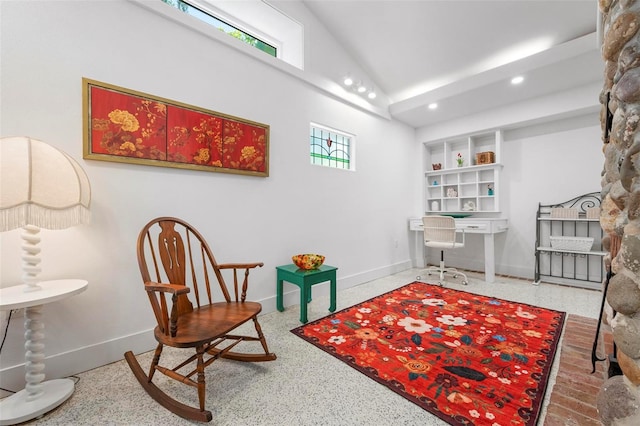 sitting room featuring plenty of natural light, vaulted ceiling, and baseboards