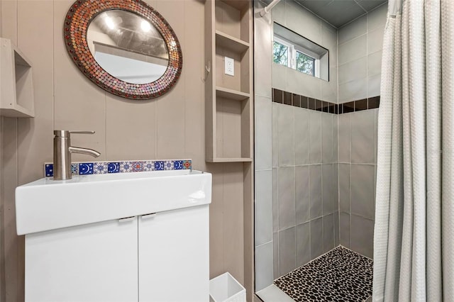 bathroom with vanity and tiled shower