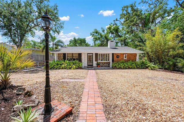 ranch-style house with fence and a chimney
