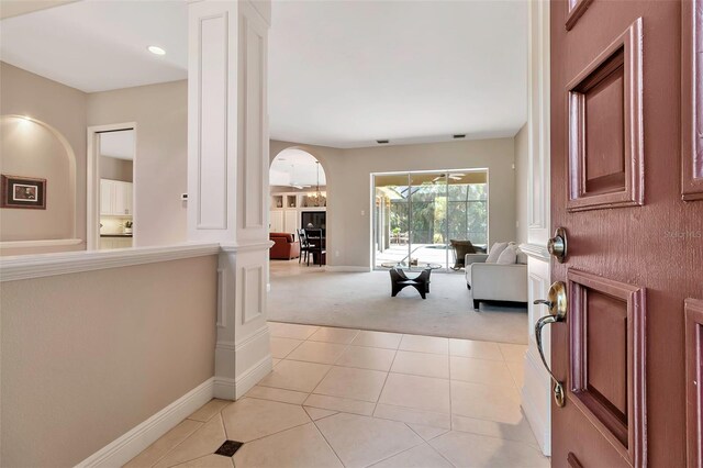 3738 Eagle Hammock Dr, Sarasota, FL 34240 - entryway with light carpet, arched walkways, baseboards, ornate columns, and light tile patterned floors
