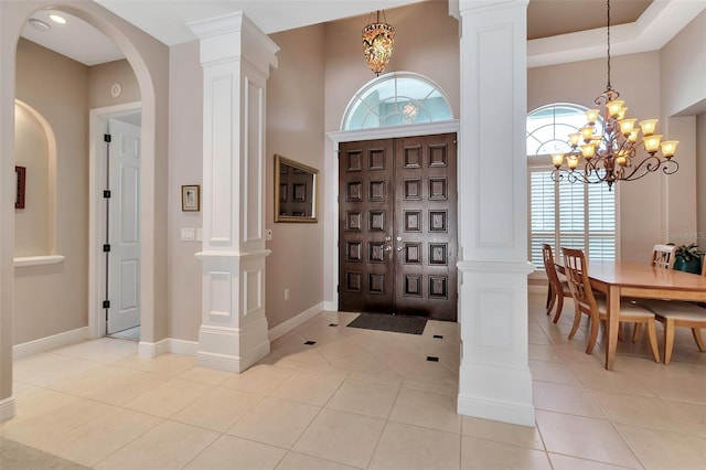 3738 Eagle Hammock Dr, Sarasota, FL 34240 - entryway with arched walkways, light tile patterned floors, an inviting chandelier, and decorative columns