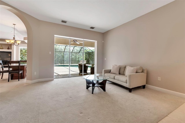 3738 Eagle Hammock Dr, Sarasota, FL 34240 - living room with arched walkways, carpet floors, visible vents, and an inviting chandelier