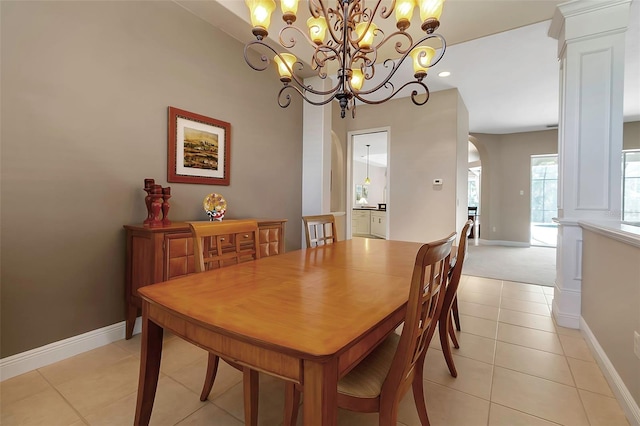 3738 Eagle Hammock Dr, Sarasota, FL 34240 - dining space with arched walkways, light tile patterned flooring, decorative columns, baseboards, and an inviting chandelier