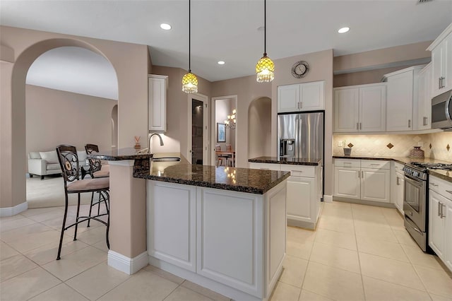 3738 Eagle Hammock Dr, Sarasota, FL 34240 - kitchen featuring arched walkways, a peninsula, appliances with stainless steel finishes, and a sink